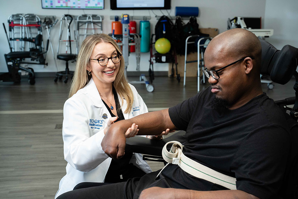 Brooks Rehabilitation doctor working with a spinal cord injury patient