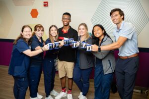 Silas Turner posing with his therapy team holding specially made coffee cups.