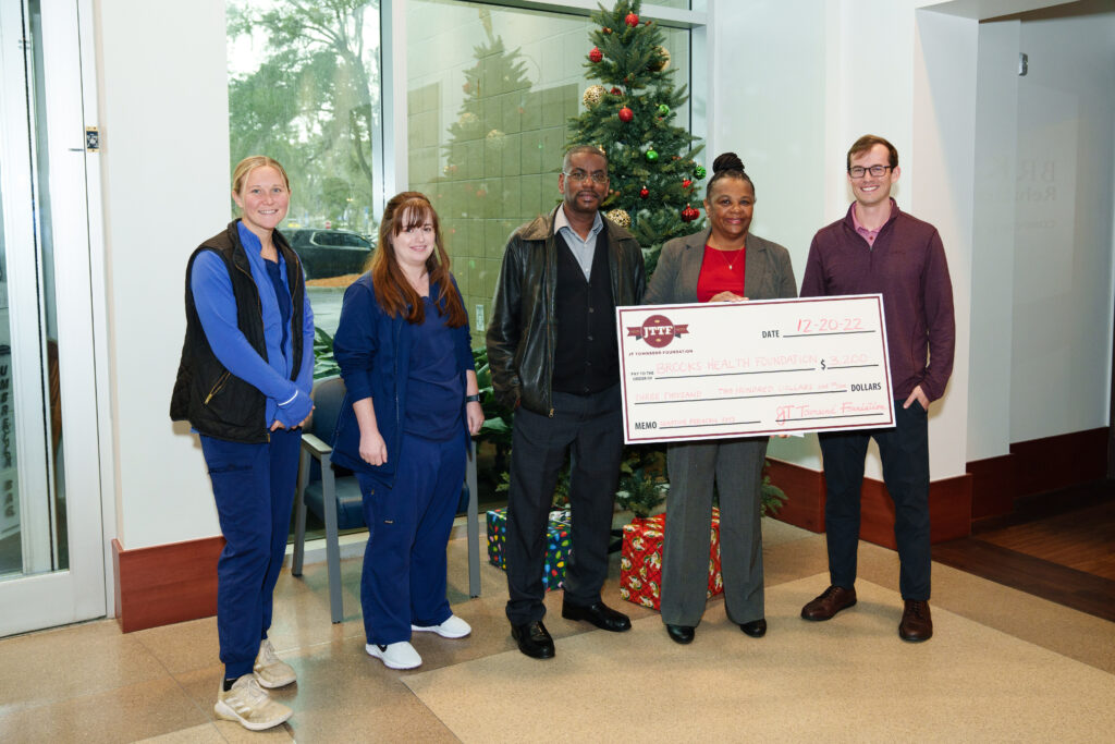 group of people holding a big cardboard check
