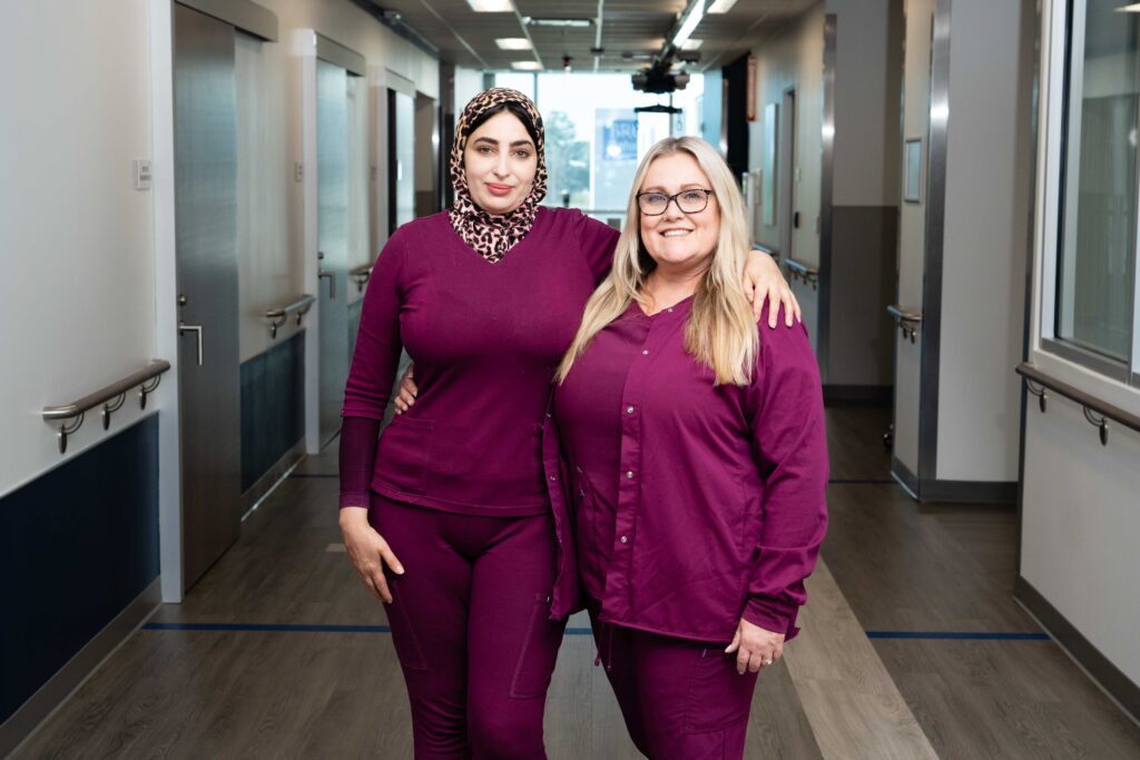 Two Brooks nurses stand in the bartram hospital hallway.