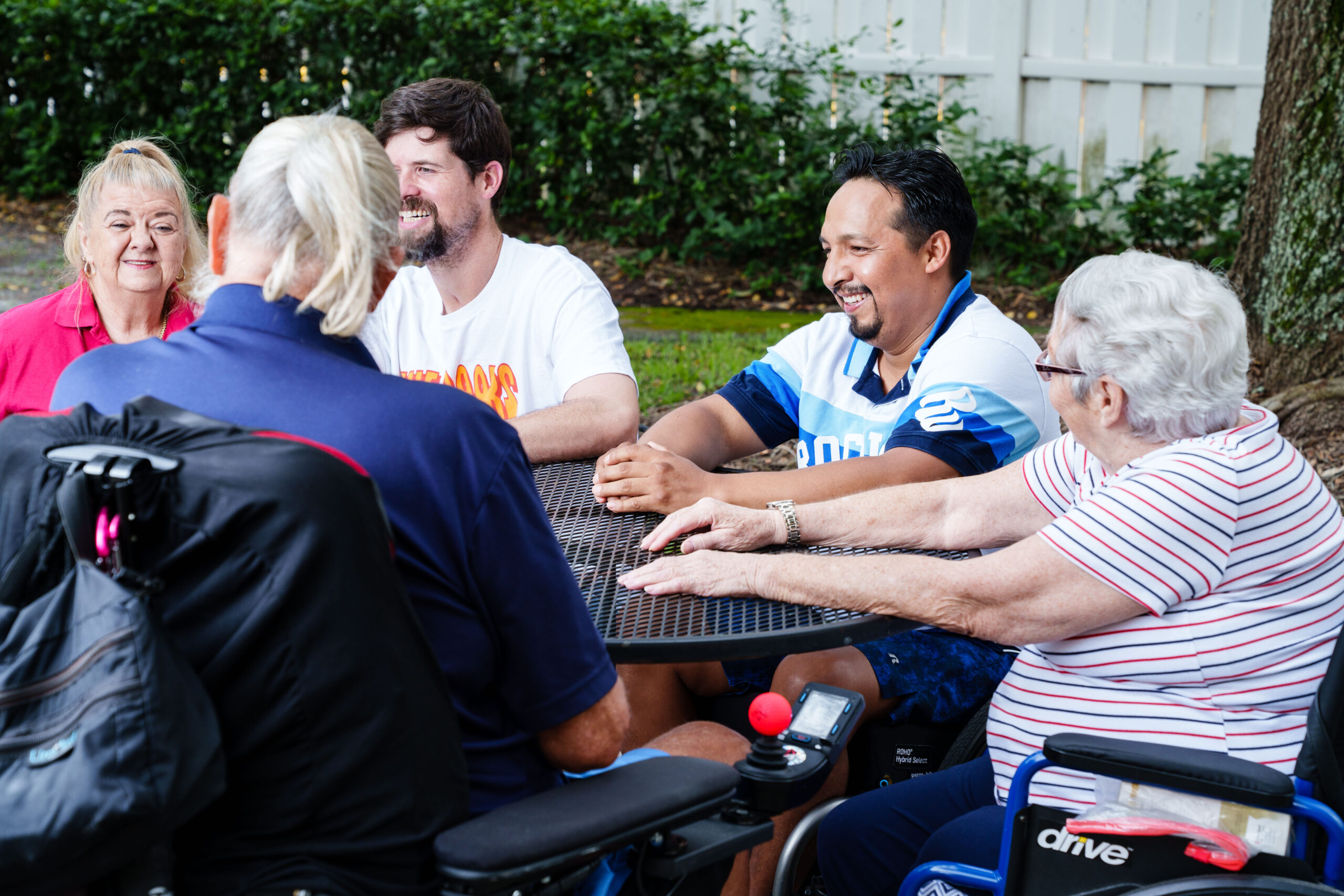 a group of peer mentors socialize around a table at Brooks Rehabilitation.