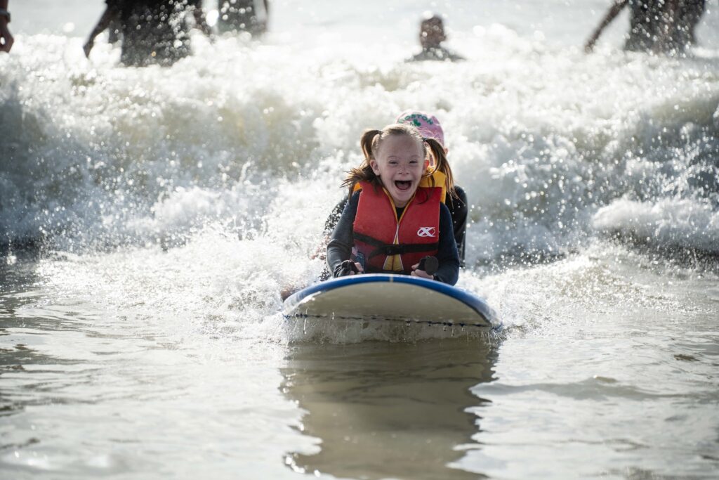 little girl participating in Brooks' adaptive surfing event.