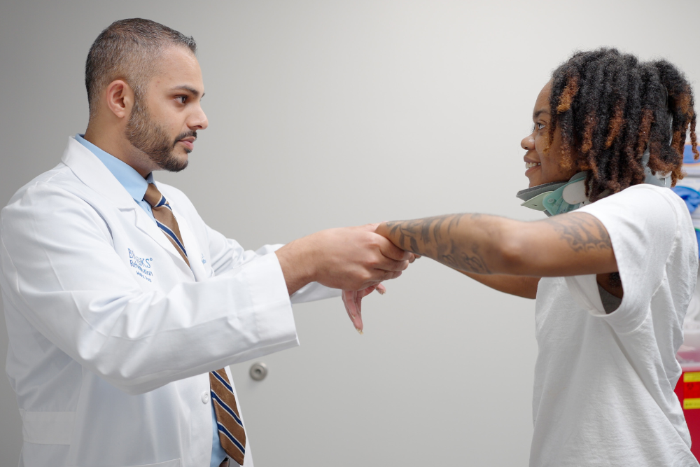 Dr. Persaud evaluates a hypoxic brain injury patient at the Brooks Medical Group practice.