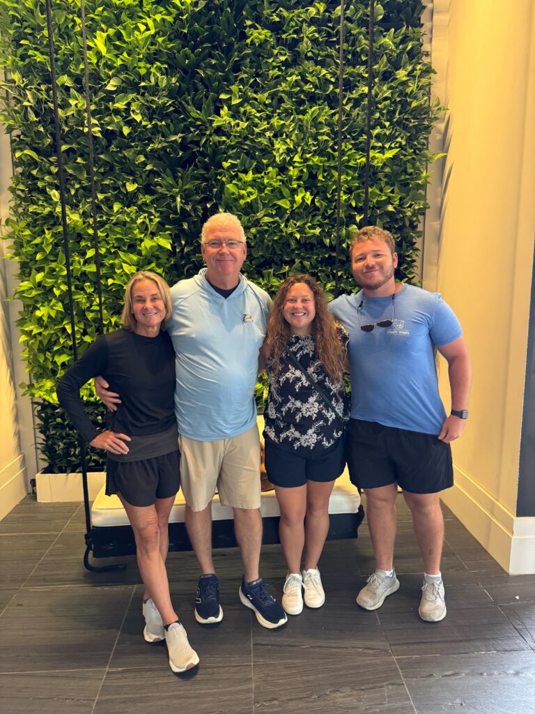 Jon Dasher and family posing in front of greenery