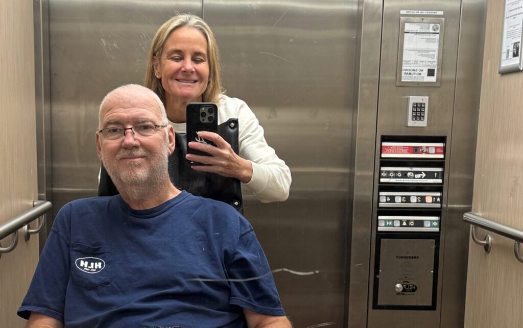 Jon Dasher and loved one posing in elevator