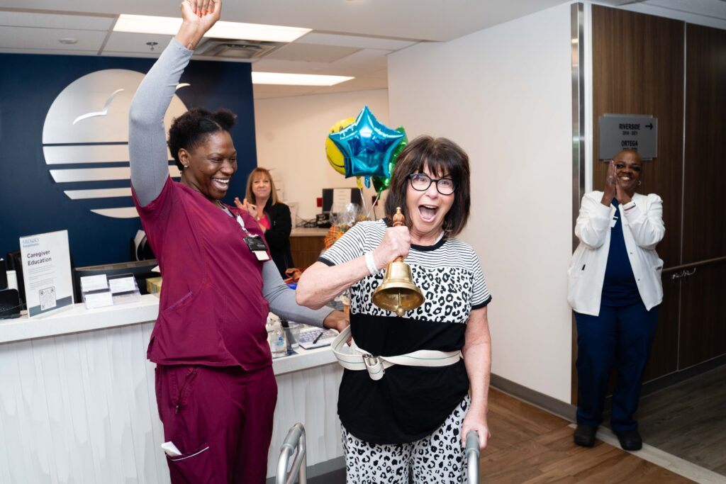 Patient ringing bell excitedly with therapist