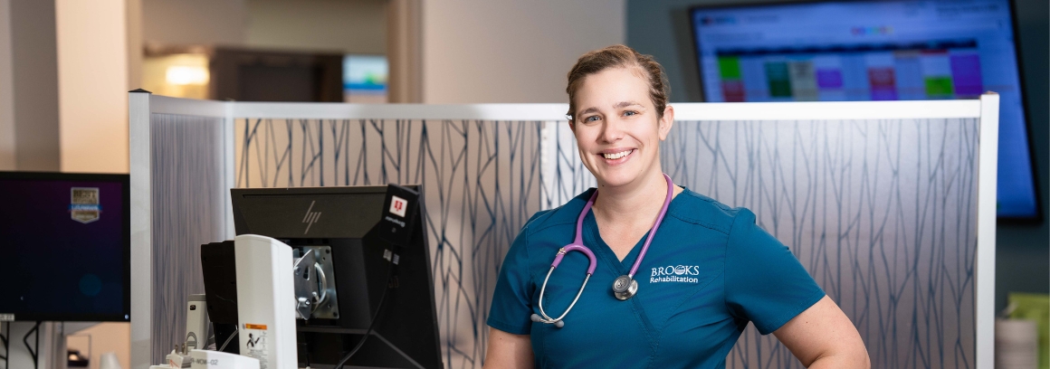 Kathryn Romanek, JU scholarship recipient at Brooks, stands next to the nursing station.