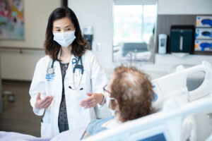 Dr. Lee talking to transplant patient at bedside