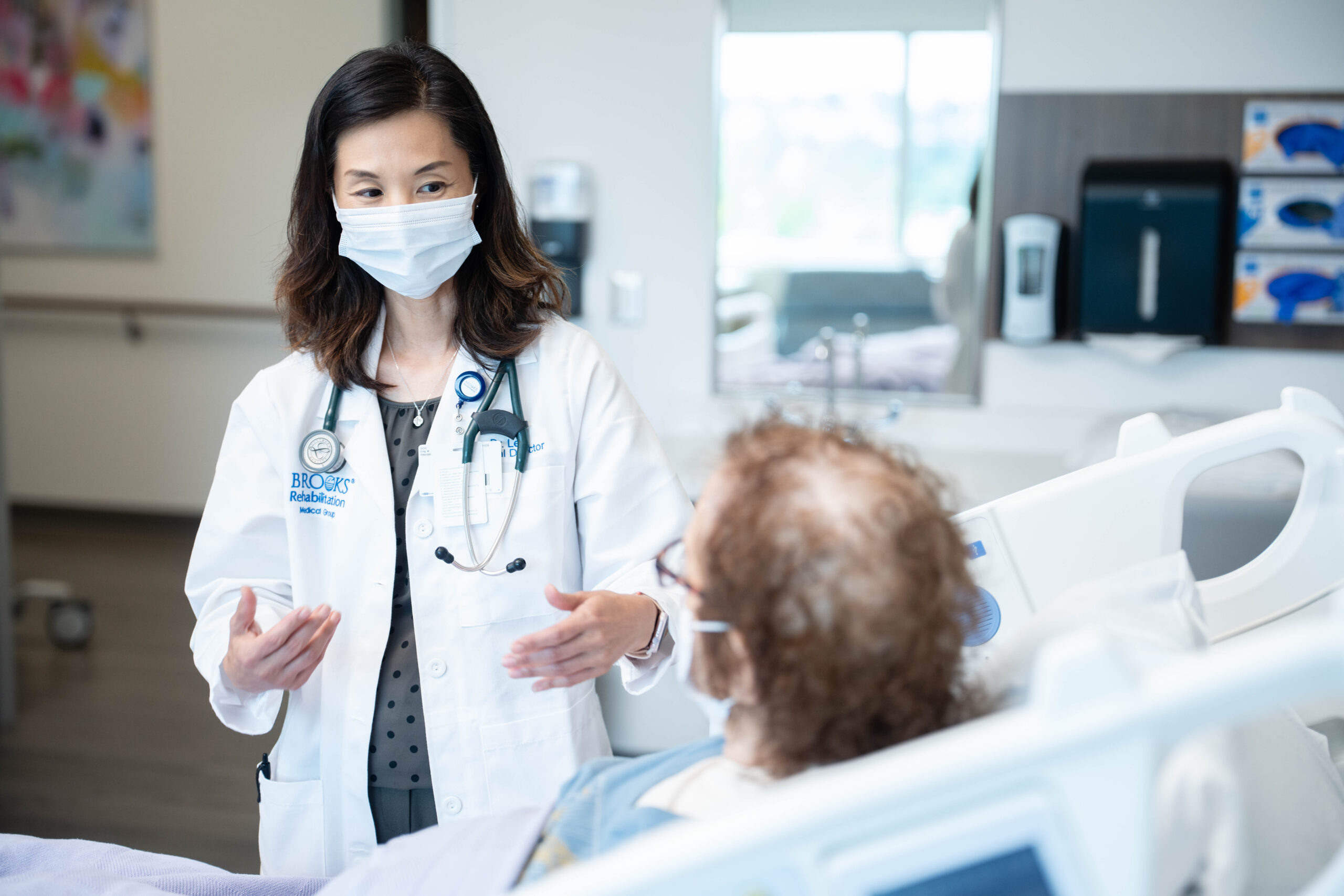 Dr. Lee talking to transplant patient at bedside