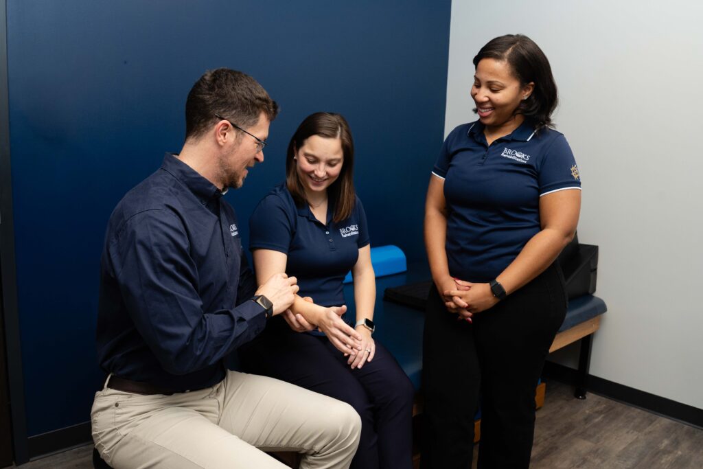Clinician educating therapy residents on proper patient examination techniques