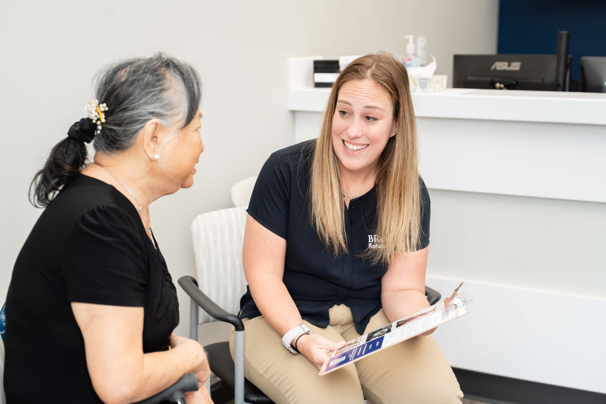 A clinical researcher is sitting next to a stroke survivor discussing how to become a research participant.