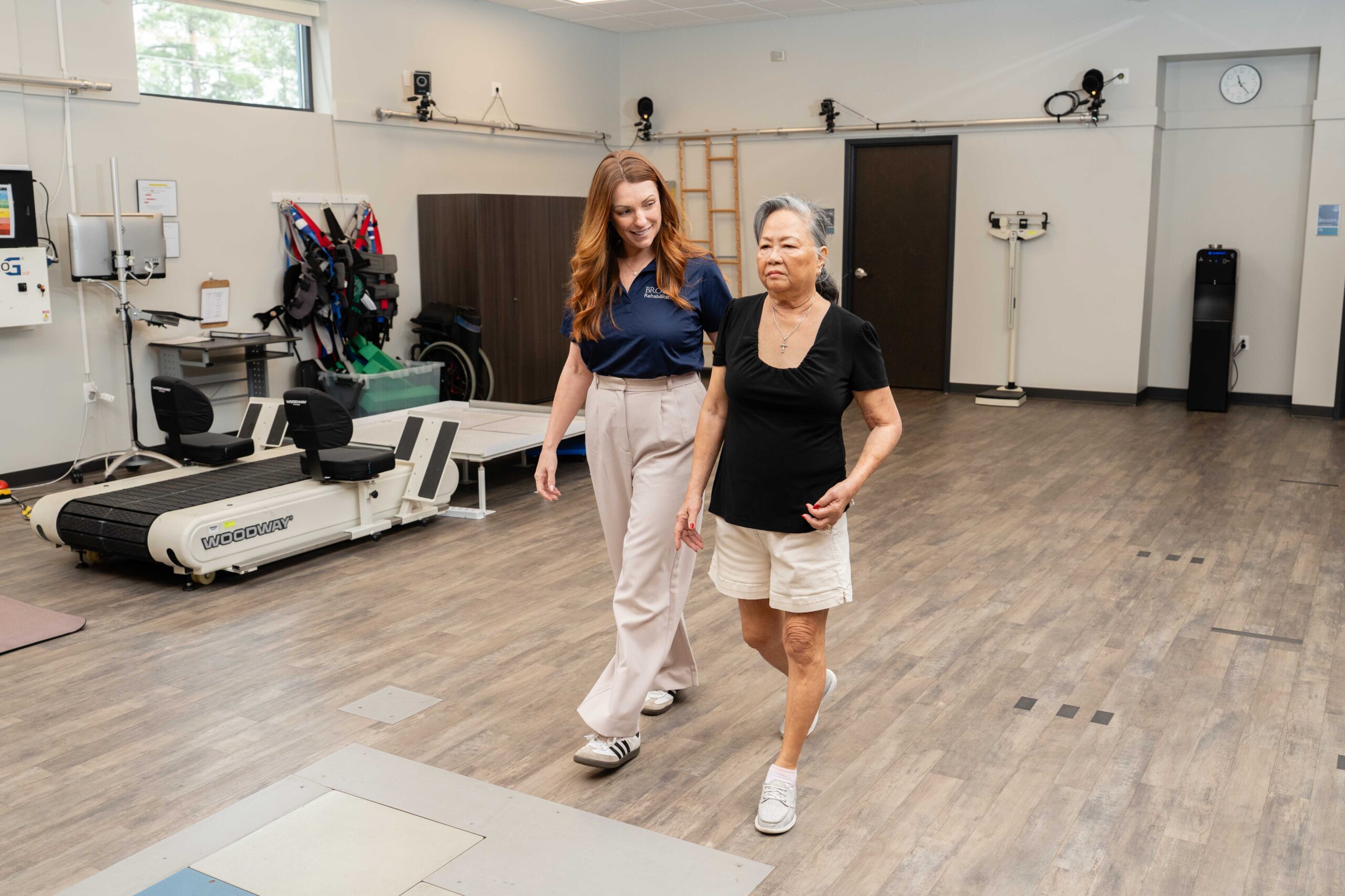 a Brooks Clinician helps a stroke patient practice walking to measure improvement.