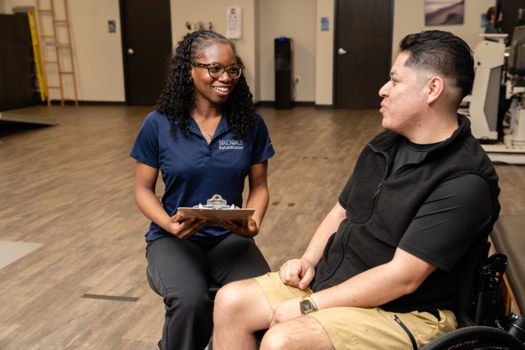 a clinical research investigator talks to a spinal cord injury patient about participating in a research study.