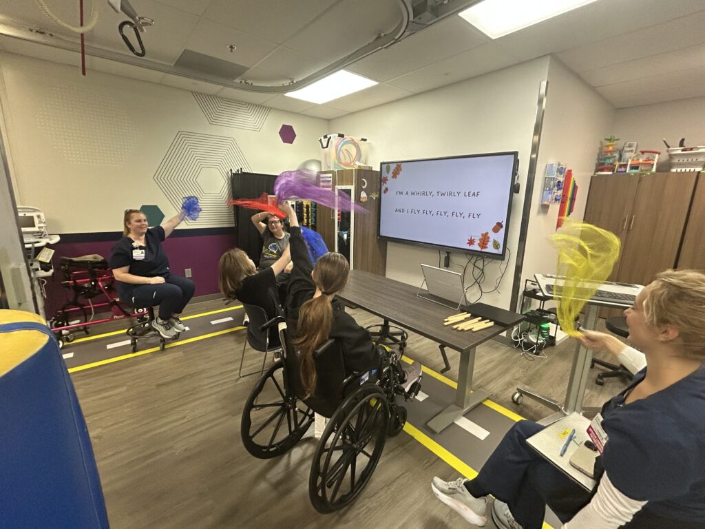 Music therapist with guitar and patient in front of piano