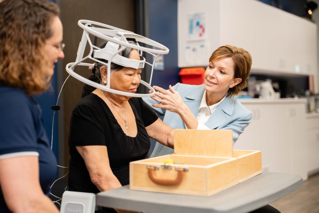 Director of clinical research at Brooks sits with a research participant in the Brain Q study.