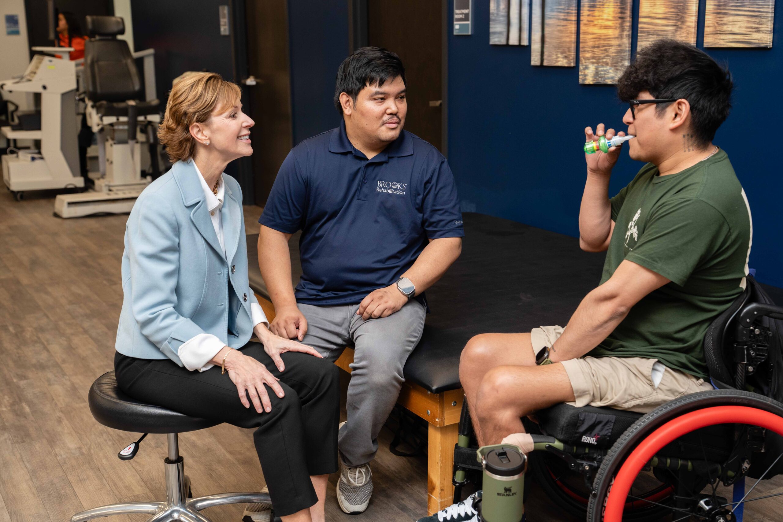 Researchers conduct a respiratory test on a young male spinal cord injury patient in a wheelchair.