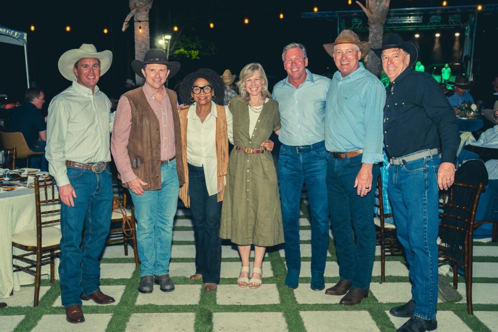people posing in western gear at night