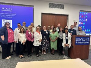 Nursing staff posing in front of screen and Brooks podium