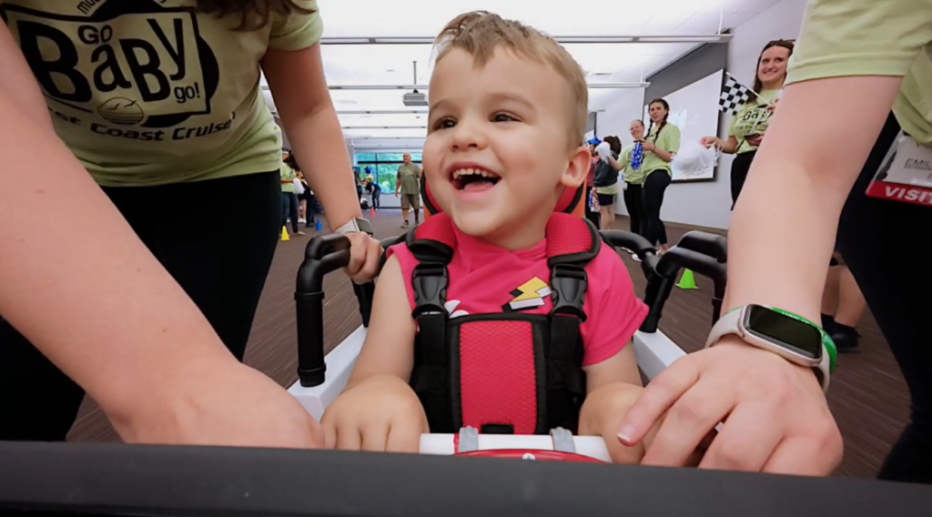 Child smiling in Go Baby Go car