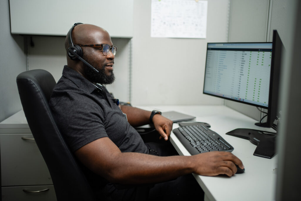 Dean Ojo sitting at desk with headphones