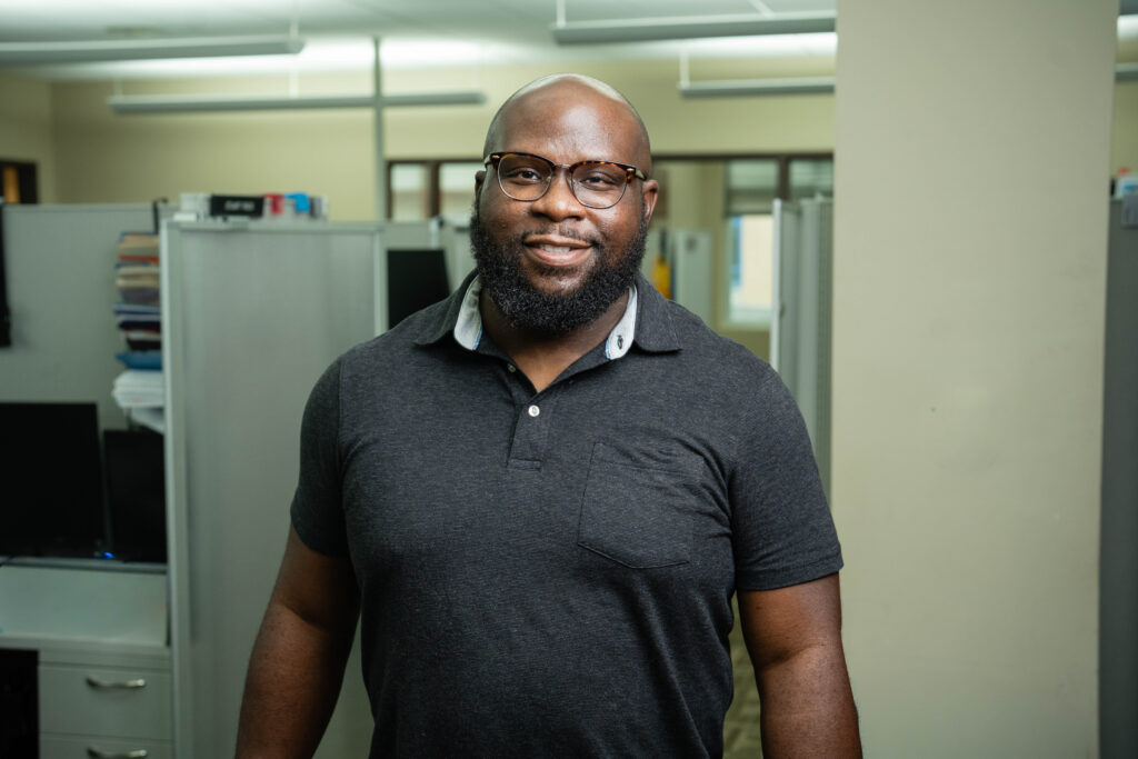 Dean Ojo posing in Brooks IT office