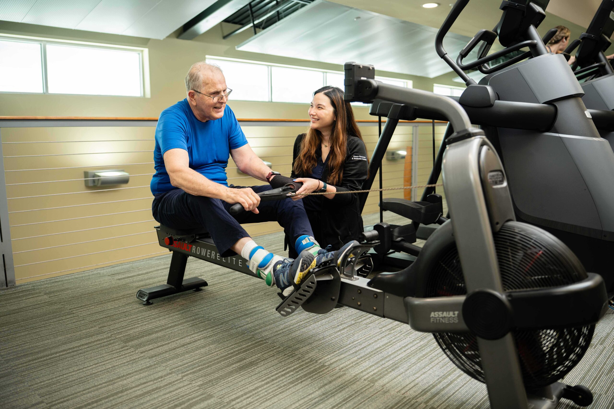 Therapist helping patient on exercise machine