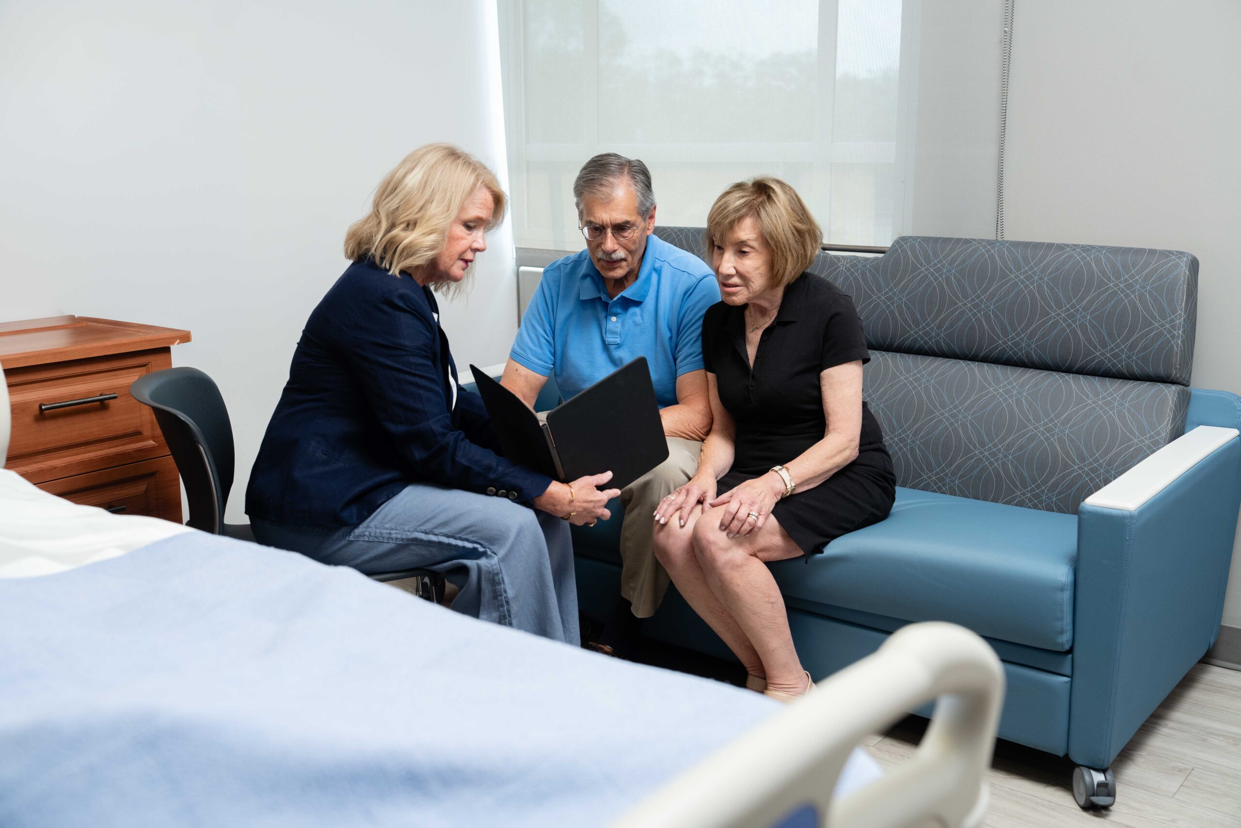 caregiver trainer sitting with caregivers showing ipad